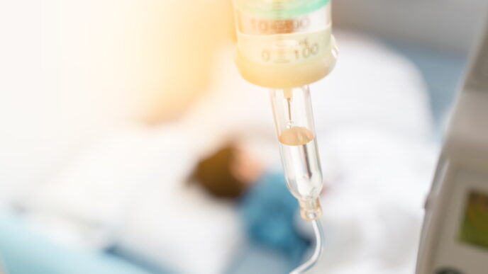 Sick child sleep on the bed in hospital during have a saline drip